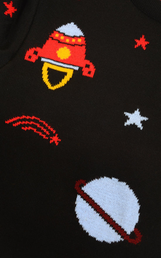 Close up shot of the retro rocket outer space jumper fabric which shows blue and red planets, stars and retro inspired rockets on a black base.