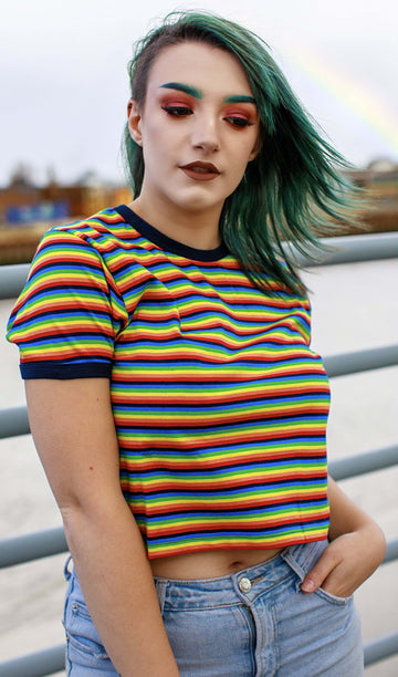 Kat is wearing the Rainbow Brights Repeat Striped Cropped T Shirt and has green coloured hair and matching eyebrows
